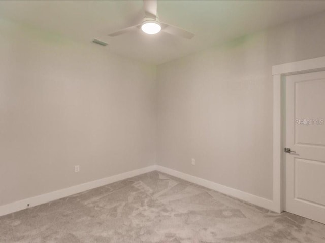 empty room with ceiling fan and light carpet