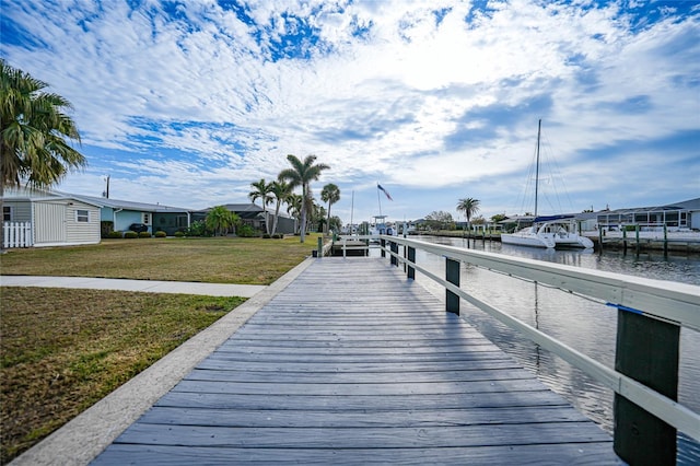 dock area with a water view and a lawn