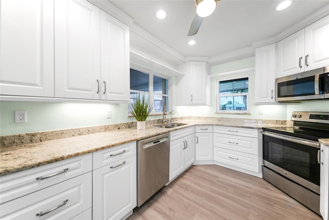 kitchen featuring stainless steel appliances, white cabinetry, and sink