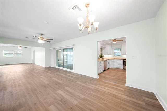 unfurnished living room with ceiling fan with notable chandelier, light hardwood / wood-style floors, and sink