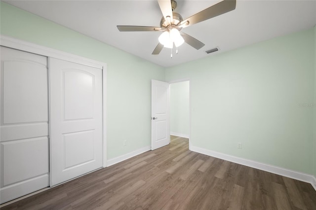 unfurnished bedroom featuring wood-type flooring, a closet, and ceiling fan