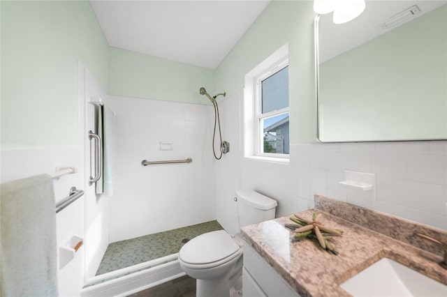 bathroom featuring a tile shower, vanity, hardwood / wood-style flooring, and toilet