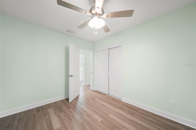 unfurnished bedroom with light wood-type flooring, a closet, and ceiling fan