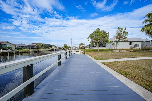 dock area featuring a lawn and a water view