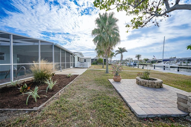 view of yard with a patio, a water view, and glass enclosure