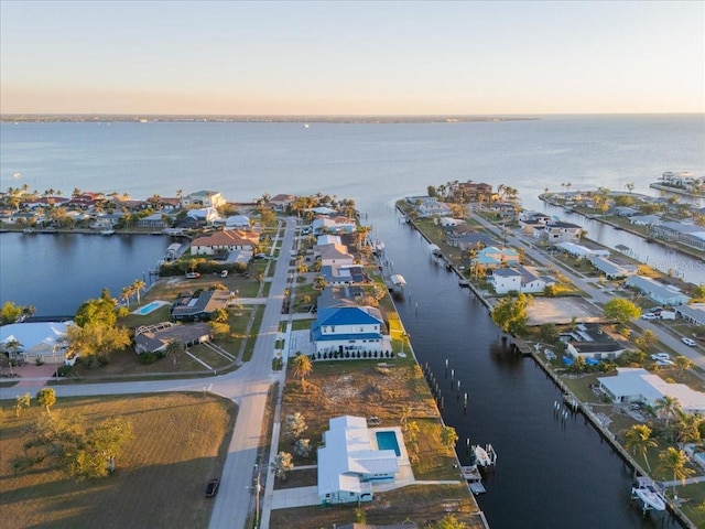 aerial view at dusk featuring a water view