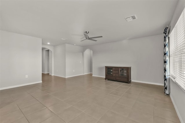 tiled empty room with a wealth of natural light and ceiling fan