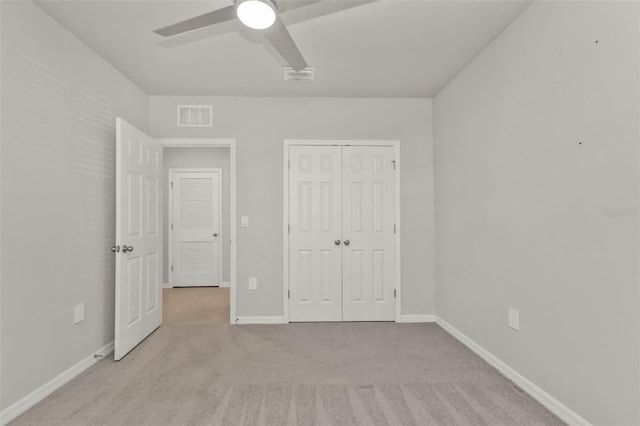 unfurnished bedroom featuring light colored carpet, ceiling fan, and a closet