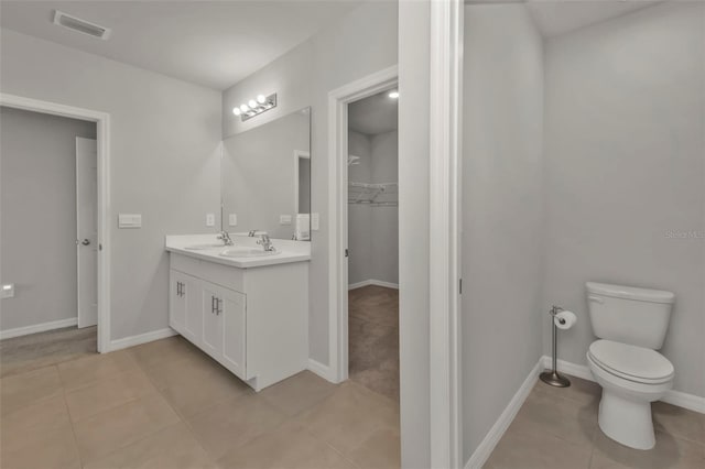 bathroom with vanity, toilet, and tile patterned flooring