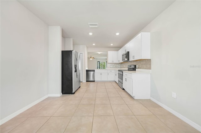 kitchen with white cabinets, decorative backsplash, ceiling fan, light tile patterned floors, and appliances with stainless steel finishes