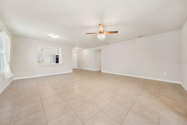 tiled spare room with ceiling fan