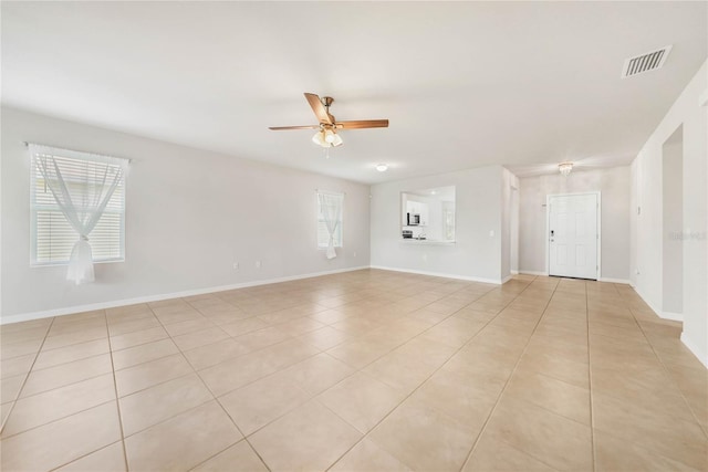 empty room with ceiling fan and light tile patterned floors