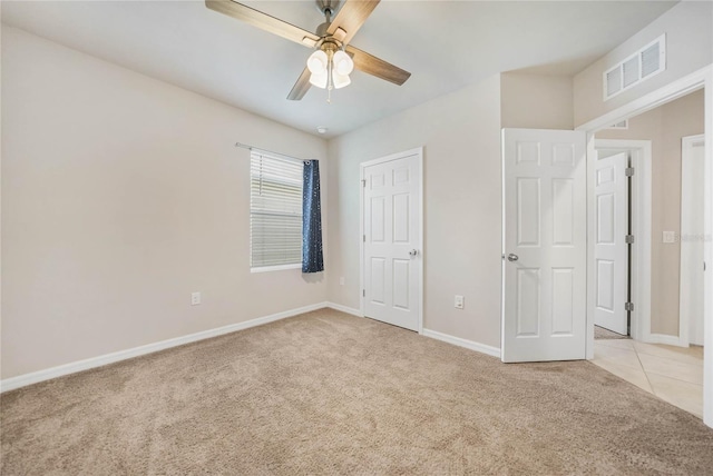 unfurnished bedroom with ceiling fan and light colored carpet