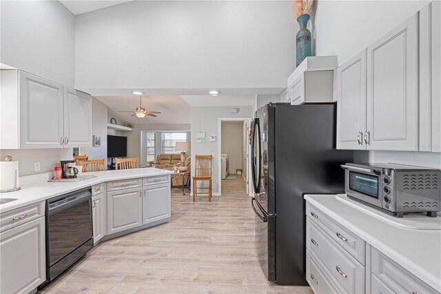 kitchen featuring light wood-type flooring, ceiling fan, dishwasher, white cabinetry, and stainless steel refrigerator