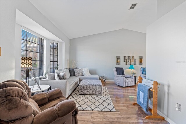 living room with vaulted ceiling and hardwood / wood-style flooring