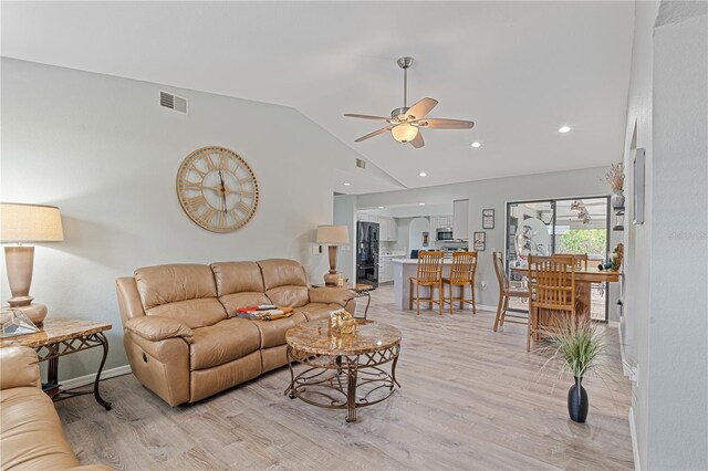 living room with light wood-type flooring, ceiling fan, and lofted ceiling