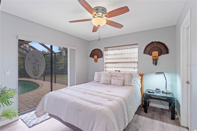 bedroom featuring access to exterior, light hardwood / wood-style floors, and ceiling fan