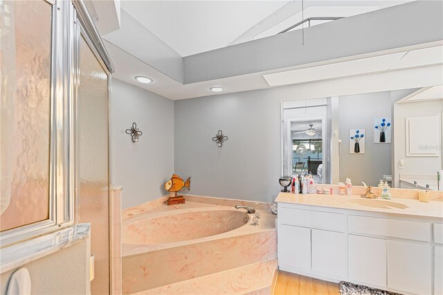 bathroom with wood-type flooring, vanity, and a tub