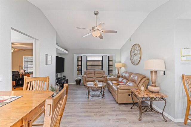 living room with a healthy amount of sunlight, light hardwood / wood-style flooring, ceiling fan, and lofted ceiling