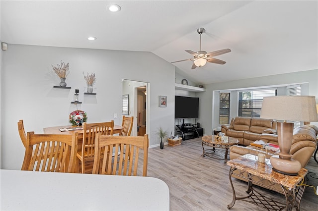 living room featuring ceiling fan, light hardwood / wood-style floors, and vaulted ceiling