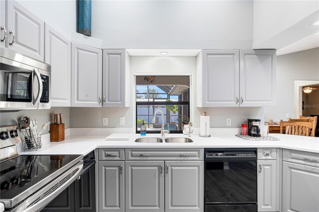 kitchen featuring stainless steel appliances, white cabinetry, and sink