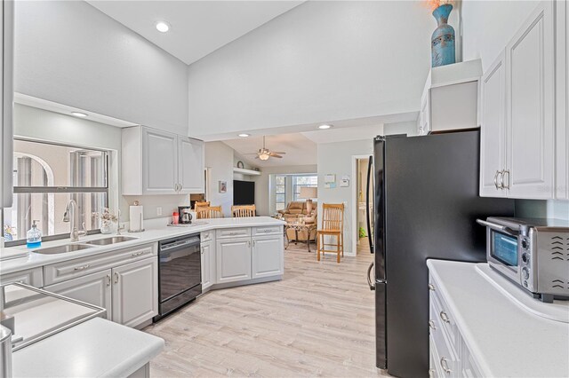 kitchen featuring white cabinets, black dishwasher, ceiling fan, and sink