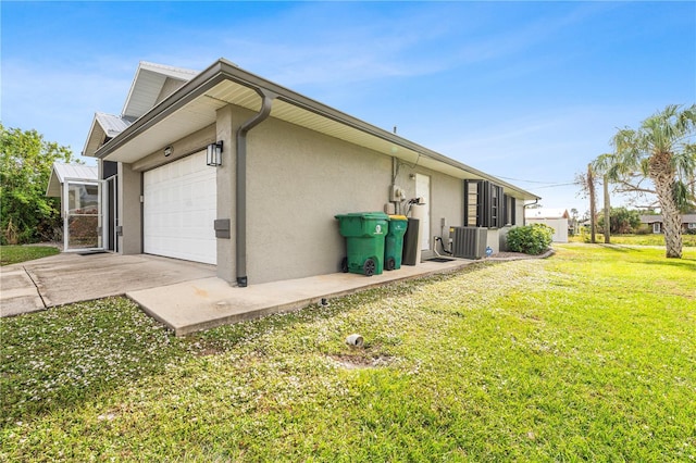 view of side of home with a yard, central AC unit, and a garage