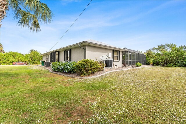 view of side of property with a lawn and central AC unit