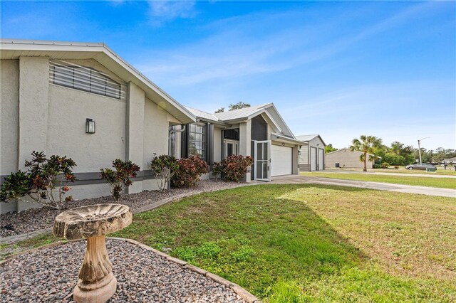 view of side of home with a garage and a yard