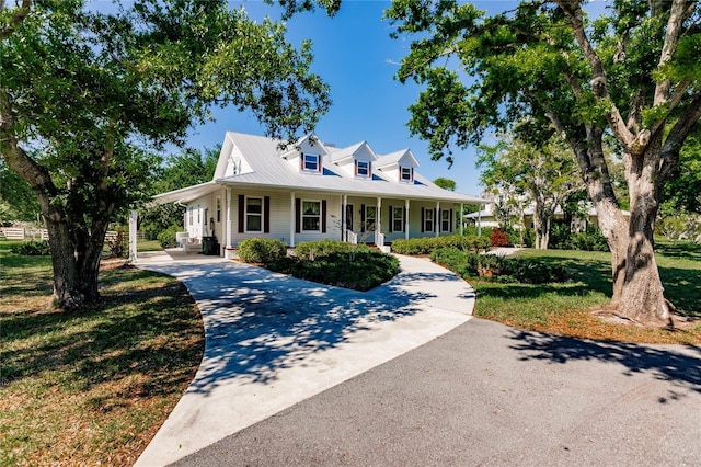 farmhouse inspired home with covered porch and a front lawn