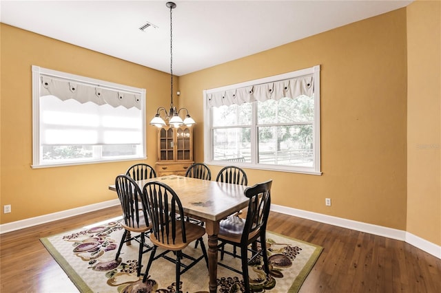 dining area with a chandelier and dark hardwood / wood-style flooring