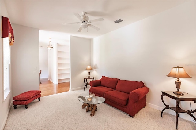 living room featuring light carpet and ceiling fan