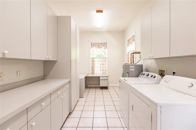 washroom featuring washing machine and dryer, electric water heater, light tile patterned flooring, and cabinets