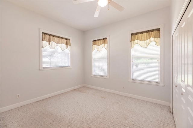 spare room featuring ceiling fan and light colored carpet