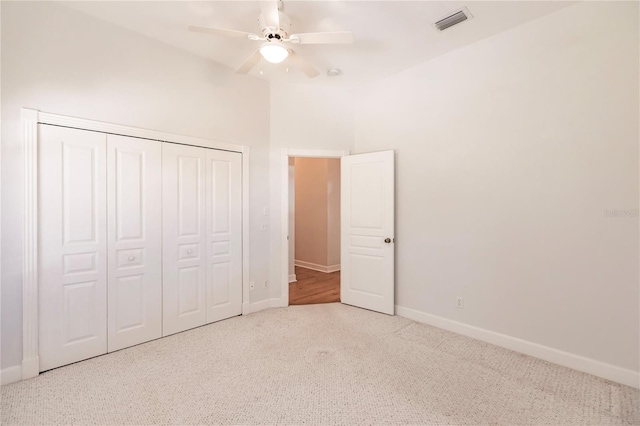 unfurnished bedroom featuring carpet flooring, ceiling fan, and a closet