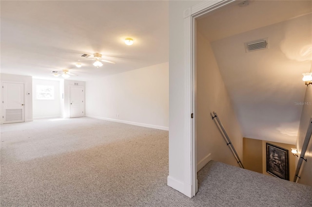 carpeted spare room featuring ceiling fan