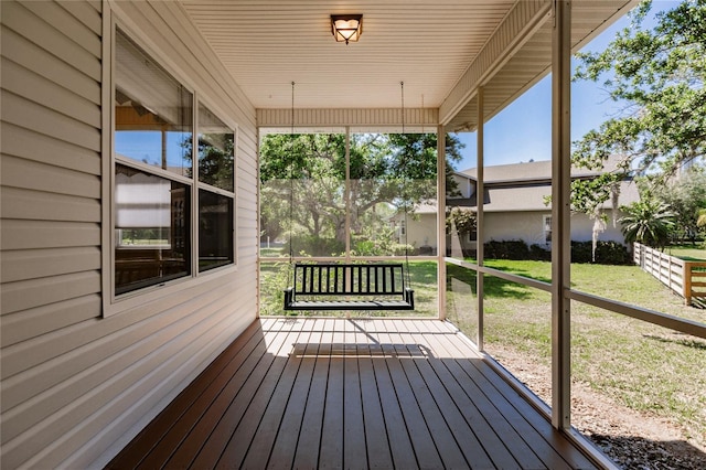 wooden terrace featuring a lawn and a porch