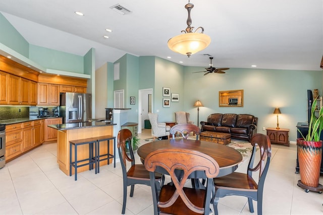 tiled dining room featuring ceiling fan and high vaulted ceiling