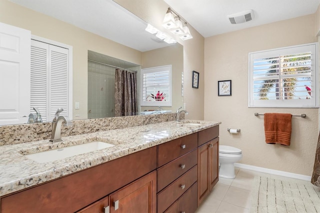 bathroom featuring vanity, tile patterned flooring, a wealth of natural light, and toilet