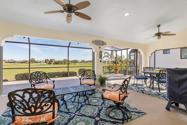 sunroom / solarium featuring a healthy amount of sunlight, vaulted ceiling, and ceiling fan