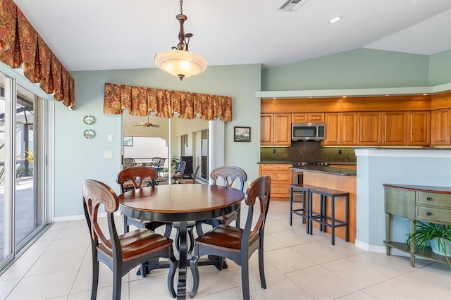 dining room featuring ceiling fan, lofted ceiling, and light tile patterned floors