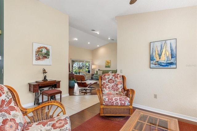 sitting room with tile patterned floors and vaulted ceiling