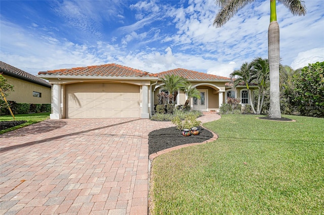 mediterranean / spanish-style home with a garage and a front lawn