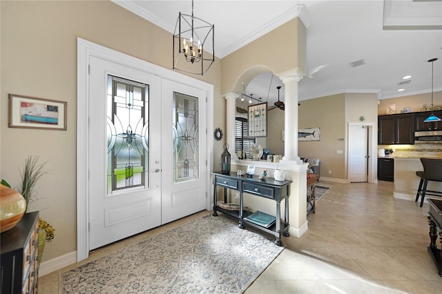 foyer with ornate columns, light tile patterned floors, ceiling fan with notable chandelier, and ornamental molding