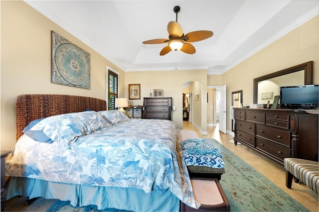 carpeted bedroom featuring a tray ceiling, ceiling fan, and crown molding