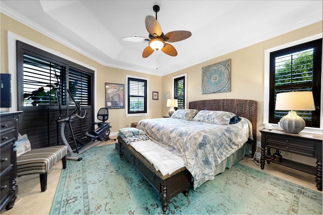 bedroom with ceiling fan, ornamental molding, and a tray ceiling