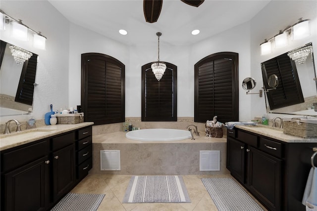 bathroom featuring tile patterned floors, tiled bath, vanity, and ceiling fan with notable chandelier