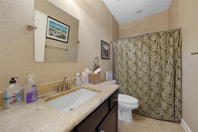 bathroom with tile patterned flooring, vanity, toilet, and walk in shower