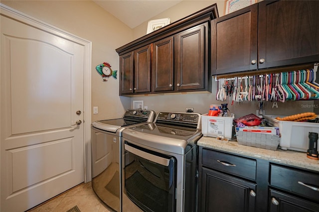 clothes washing area featuring cabinets, washing machine and dryer, and light tile patterned flooring