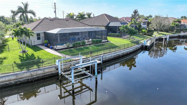 view of dock with a lanai, a yard, and a water view